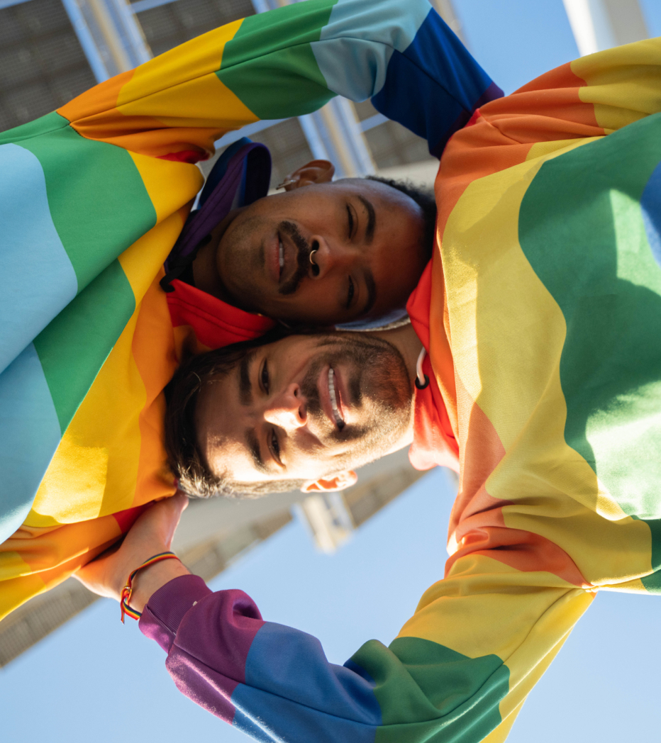 Two people with pride flag sweaters