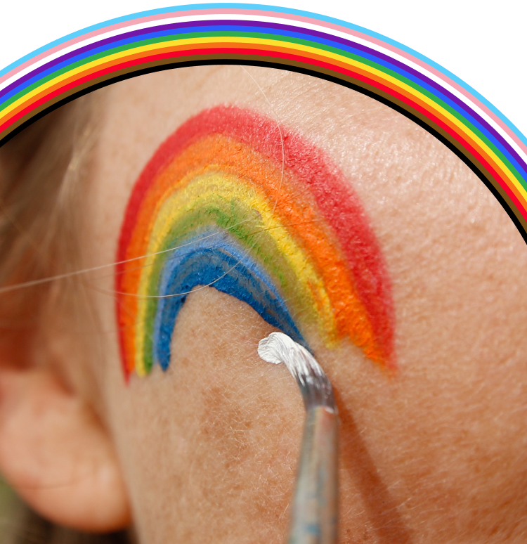 A pride flag painted on someone's cheek